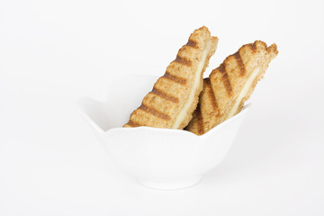Grilled cheese sandwich in white bowl. Wholewheat bread.