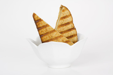 Grilled cheese sandwich in white bowl. Wholewheat bread.