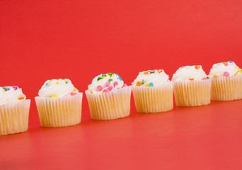 Delicious cupcakes on bright red background