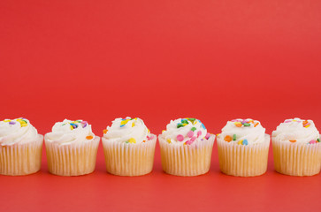 Delicious cupcakes on bright red background