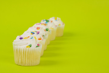 Delicious cupcakes on lime green background