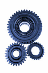 Three gears meshing together over white