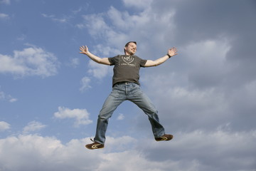 Fototapeta na wymiar man jumping against blue sky