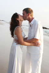 Couple kissing on the beach. - obrazy, fototapety, plakaty