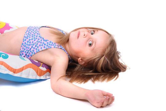 young girl in swim-suit is lying on the floor