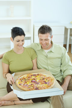 Happy couple eating pizza