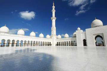 white mosque with cloudy blue sky