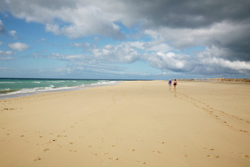 Obraz premium Menschen laufen am Strand Ozeans