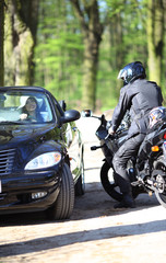 Obraz na płótnie Canvas Sexy girl in car looking a man on a motorcycle
