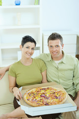 Happy couple eating pizza