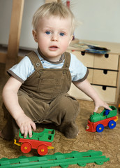 cute blond baby one years old playing in train