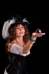 Woman in vaudeville costume peering at glass marble