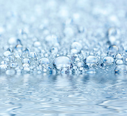 Blue droplets reflected in the water