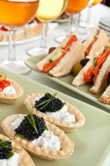 banquet table with cocktails, sandwiches and canapes
