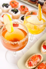 banquet table with drinks, sandwiches and canapes