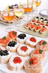 banquet table with drinks, sandwiches and canapes