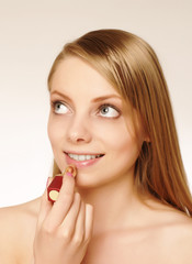 Pretty woman applying make up.