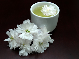 Obraz na płótnie Canvas Floral tea on a dark brown table with flowers