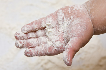 Hand of a small child in flour