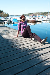 Fototapeta na wymiar Attractive young woman posing near the harbor