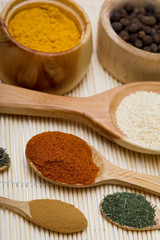 many different spices in spoons