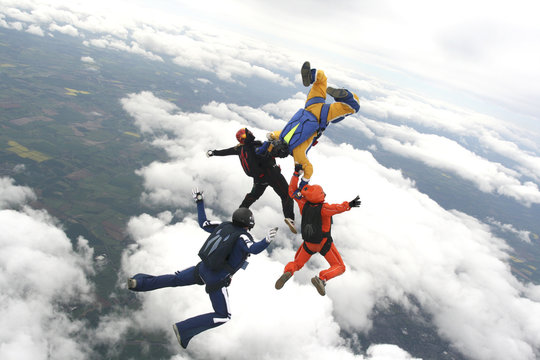 Four skydivers jump from a plane