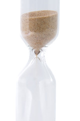 Closeup view of sand flowing through an hourglass isolated over