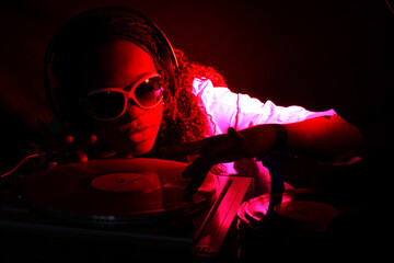 cool afro american DJ in action under red light