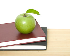 Green apple on books