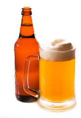 A bottle and mug of beer covered with water drops