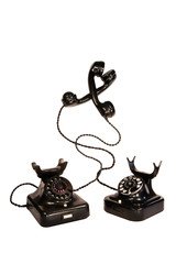 Two black vintage telephones entangled, isolation on white