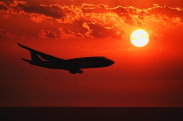 Fototapeta na wymiar Airplane flying during sunrise/sunset