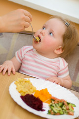 The child eats a vegetable salad