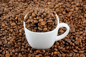 Cup of coffee filled up with beans