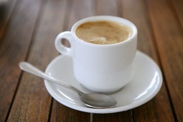 Coffe with milk white cup over teak wooden