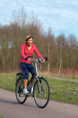 Woman cycling in a park.