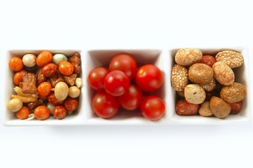 triple bowl with varied japanese snacks and tomatoes