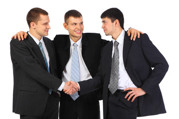 businessman observes hand shake of two others