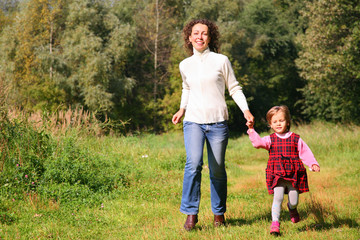 Fototapeta premium Mother with daughter run in wood, front view