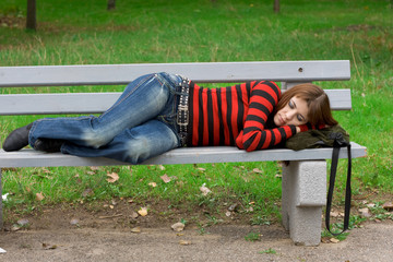 Girl sleeping on a park bench