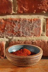red chilli paprika powder spice in bowl on wooden table