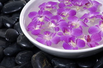 Obraz na płótnie Canvas Floral scented water and black pebbles