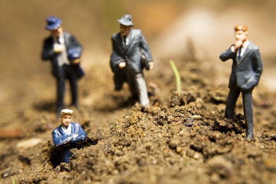Business figurines placed outside in the dirt