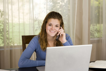 Pretty young girl using her laptop at home