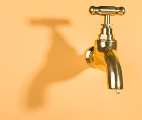 faucet in orange wall with water drop