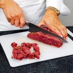 Chef cutting beef