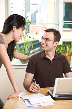 Couple paying bills by online banking