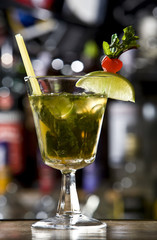 Green Alcoholic Cocktail with Orange Slice and Red Cherry