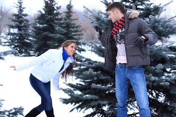 guy and girl play with each other in winter park