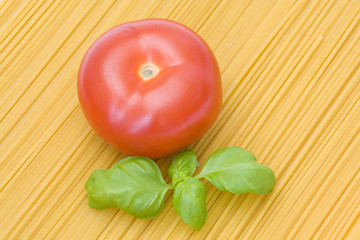 tomato and basil on spaghetti background